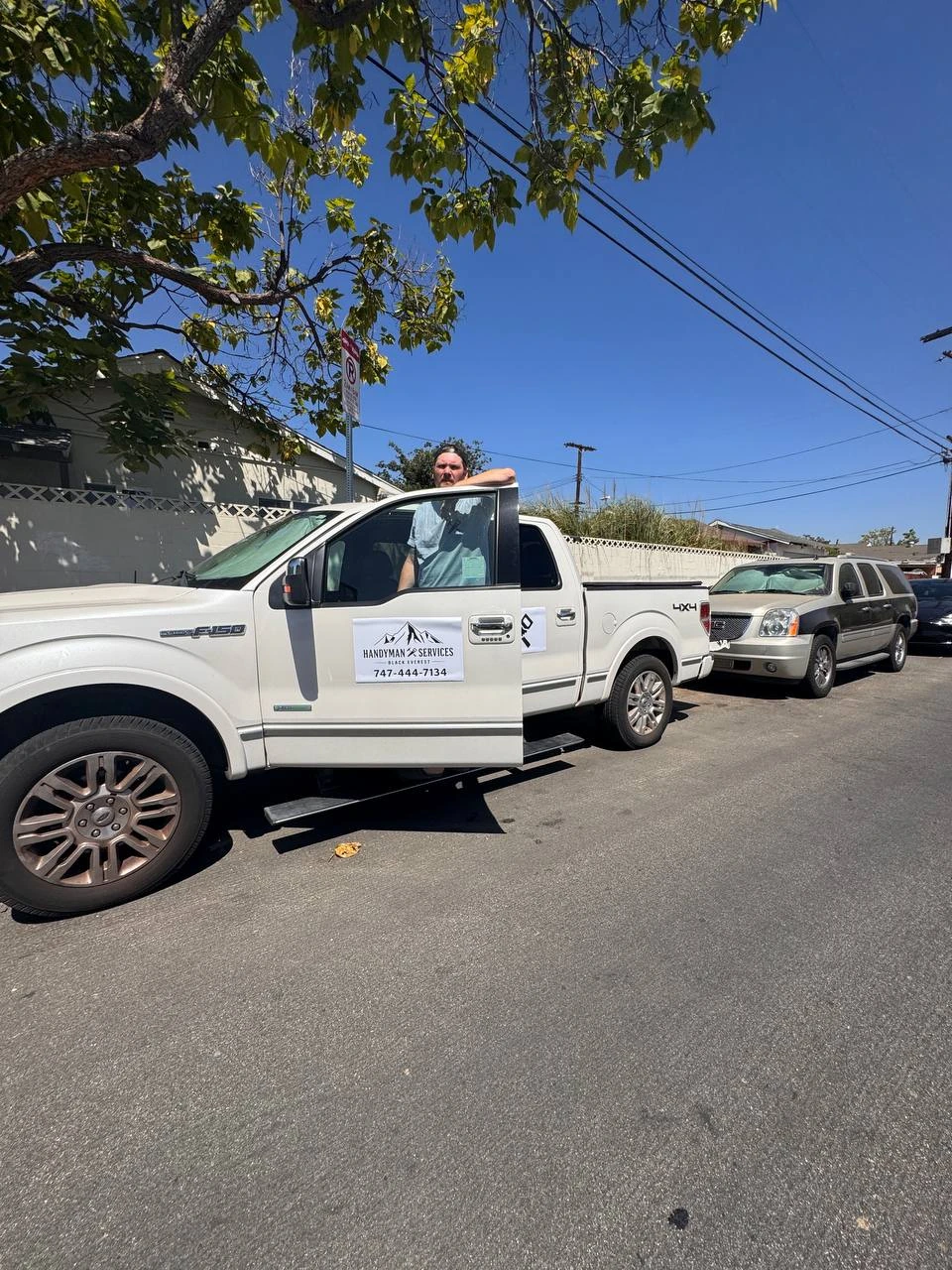 Black Everest handyman beside service truck