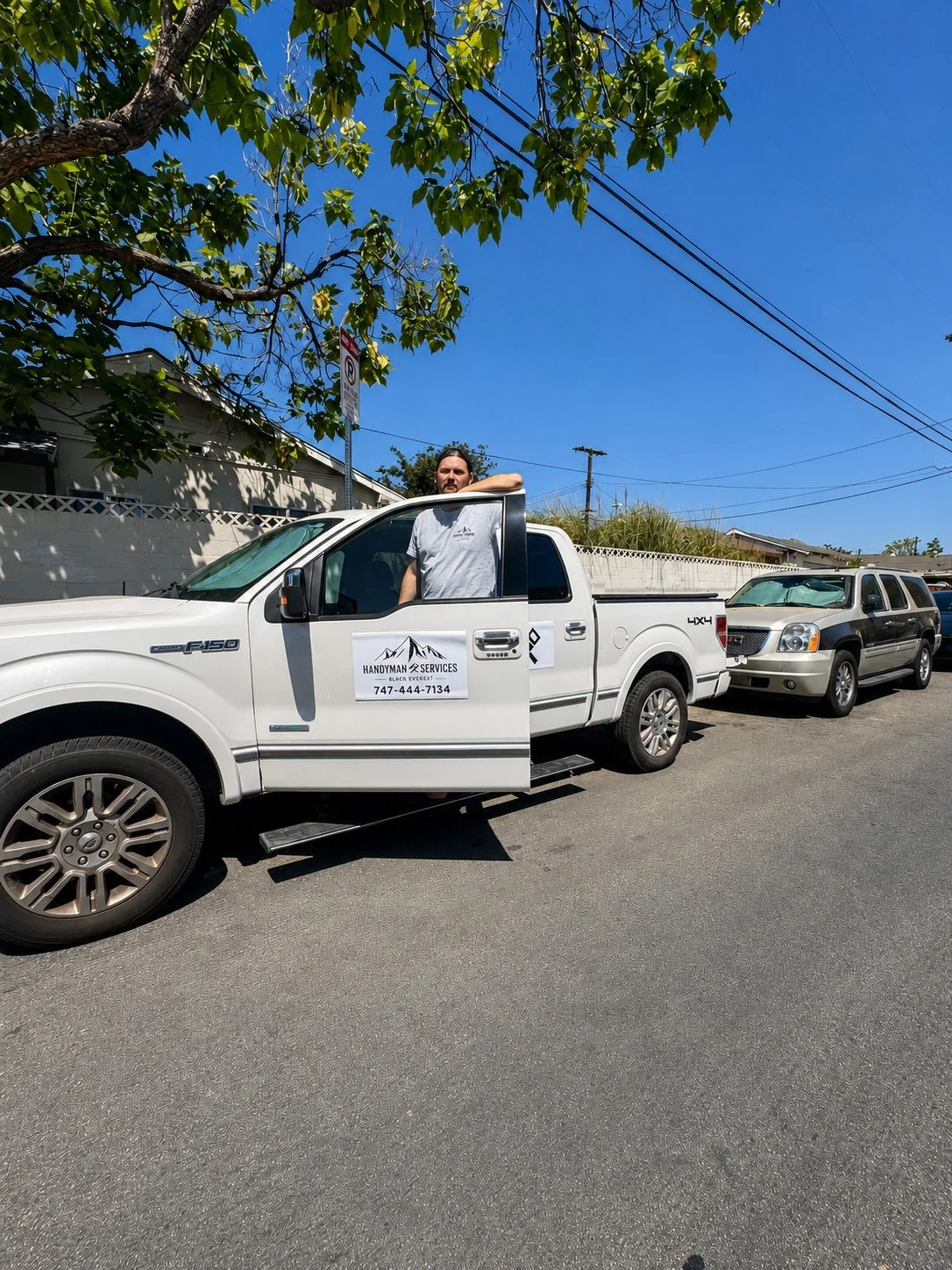 Black Everest handyman beside work truck